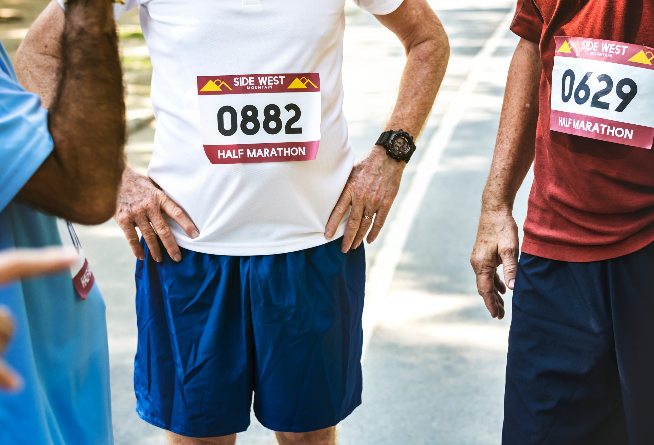 close up of group of men wearing half marathon runner bibs