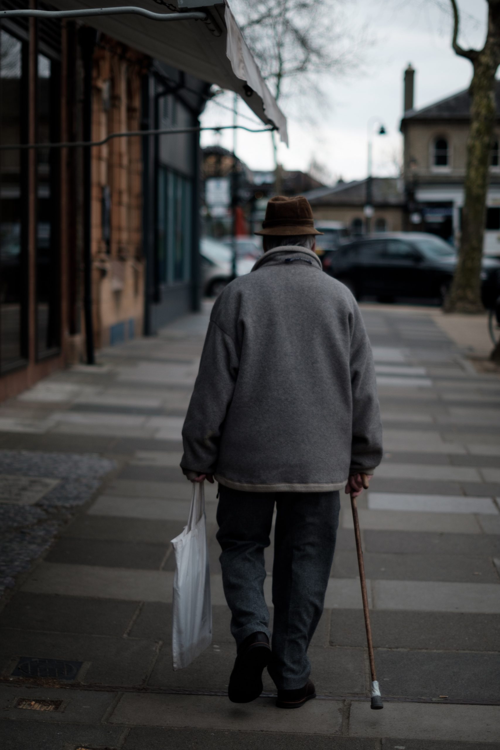 senior male walking down empty street